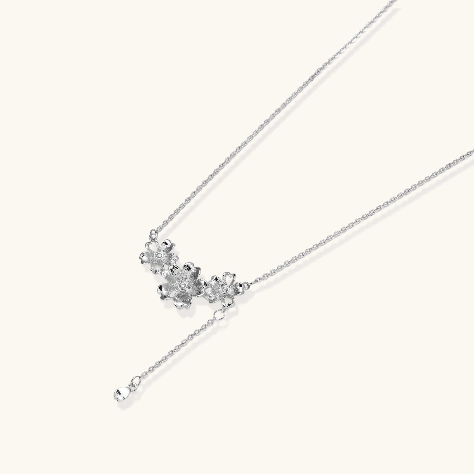 White gold plated Y-shaped necklace with three dimensional flower charms and adjustable drop pendant